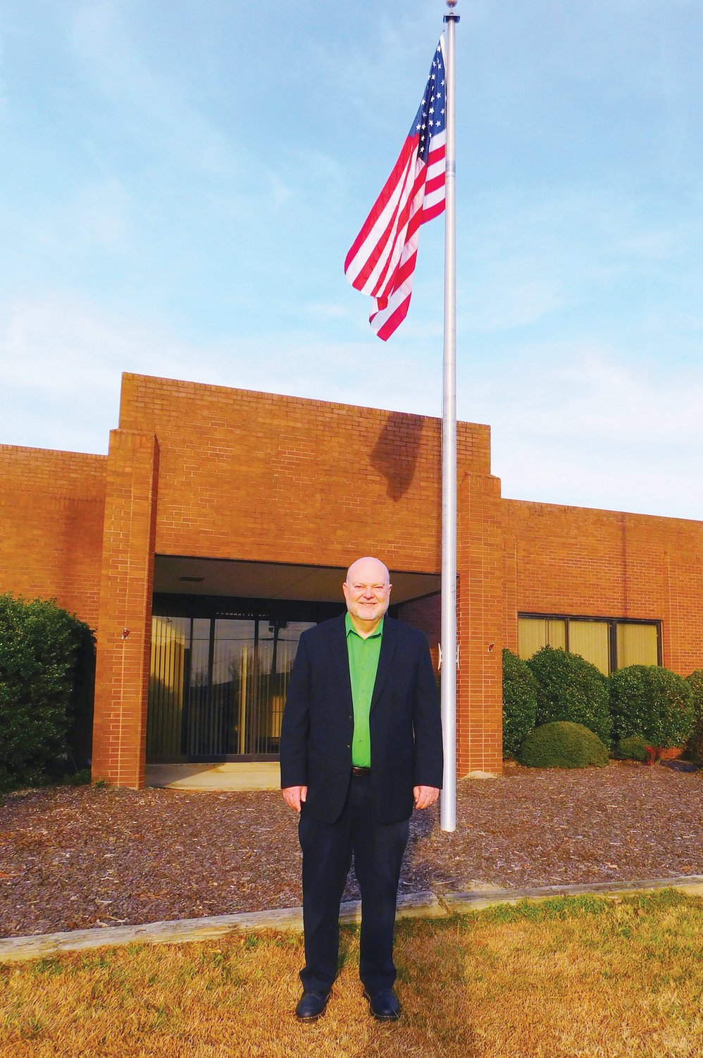 CCCC alumnus E. Eugene Moore poses in front of the Manufacturing and Biotech Solutions Center that will bear his name.